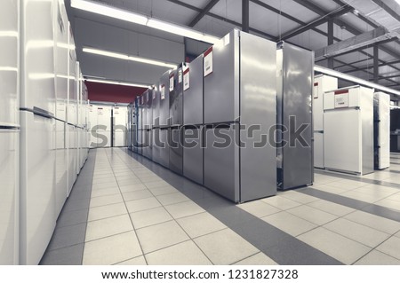 Rows of fridges in appliance store's showroom, toned image Royalty-Free Stock Photo #1231827328