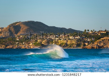 A wave breaks in front of Los Cabos, San Jose Mexico on the Baja peninsula. Royalty-Free Stock Photo #1231848217