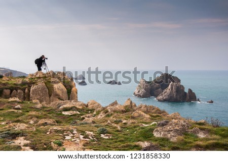 Photographer with tripod taking pictures on the Cantabrian coast