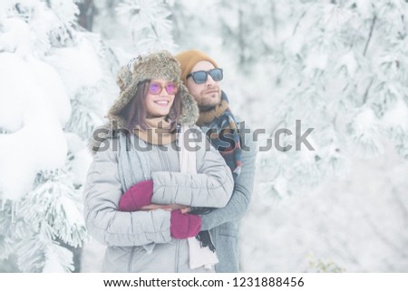 Young couple holding each other in snow outdoors 