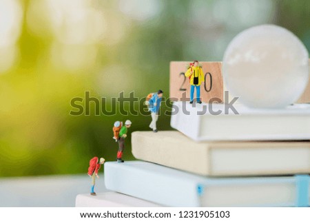 Miniature model : Traveler climb to the wood block number 2019 using as background business , new year, holiday concept, wallpaper with copy space