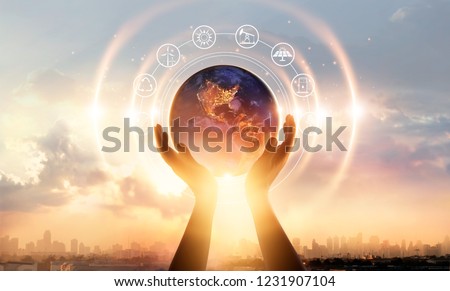 
Abstract palm hands touching earth at night on sunset city background. Earth day. Energy saving concept, Elements of this image furnished by NASA