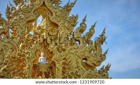 Golden Thai Line Art pattern and with Buddha on blue sky, expressing the calmness of Buddhism, in Chiang Rai, Thailand. 