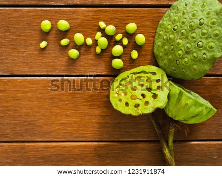 Lotus seeds and group of lotus pods put on wooden planks table top,background.