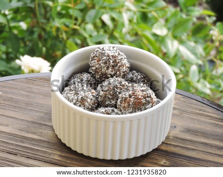 Vegan/Plant based chocolate and coconut bliss balls photographed outdoors Royalty-Free Stock Photo #1231935820