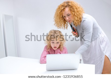 busy mother helps her daughter to do the homework at home. close up photo