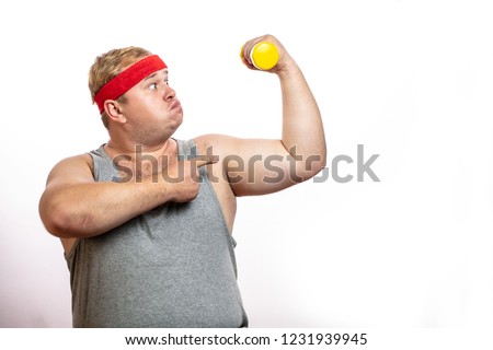 Ironic funny picture of obese corpulent man shows muscles and strength, screaming from physical effort, while lifting little dumbbell in one hand, isolated shot over white background with copyspace