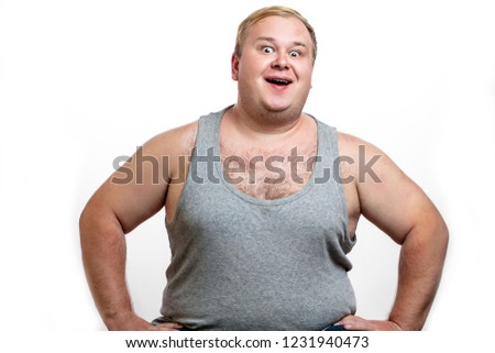 Funny picture of cheerful obese man on white background, looking at camera with happy expression. People, unhealthy lifestyle, diet and obesity concept.