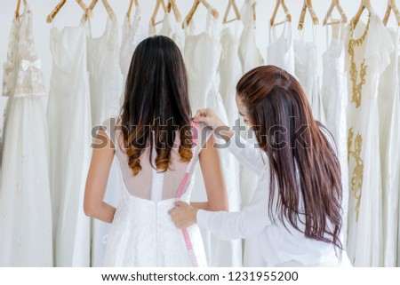 Staff measuring bride dress for cut wedding dress. Marriage concept.