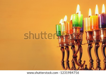 image of jewish holiday Hanukkah background with menorah (traditional candelabra) and colorful oil candles. Selective focus