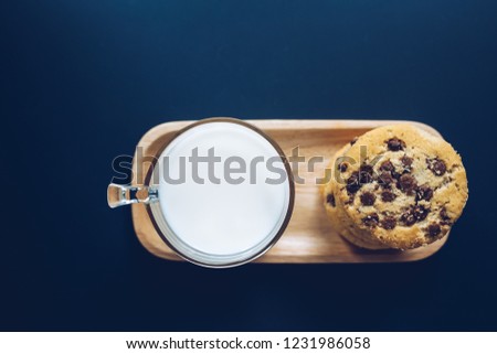 fresh milk and homemade cookies take from the top on the wooden dish and navy background