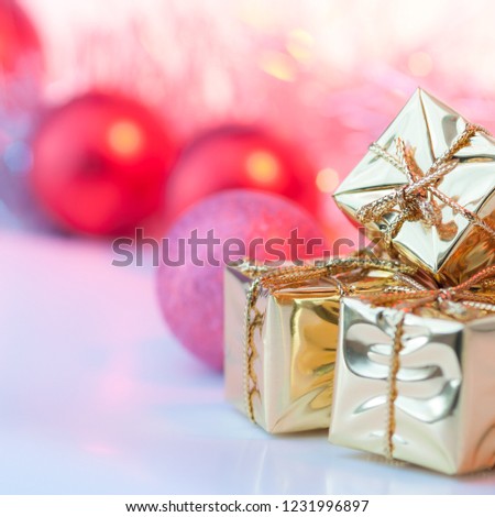 Merry Christmas, New Year, gifts in gold boxes, red Christmas balls in the right corner. Background bokeh.