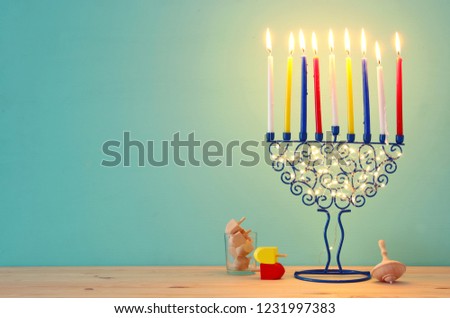 image of jewish holiday Hanukkah background with menorah (traditional candelabra) and colorful candles.