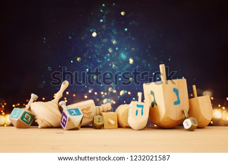 Banner of jewish holiday Hanukkah with wooden dreidels (spinning top) over glitter shiny background