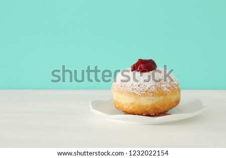 Image of jewish holiday Hanukkah with traditional doughnut on the table