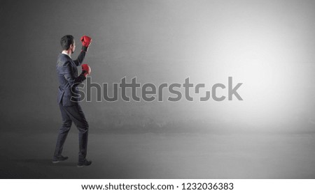 Businessman fighting with boxing gloves in an empty space