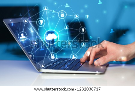 Hand using laptop with centralized cloud computing system and network security concept