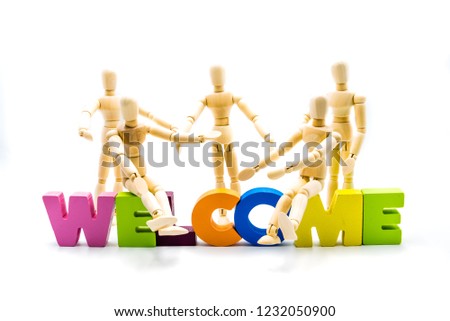 Wooden figures posing as business men behind the word WELCOME, high key isolated on white.