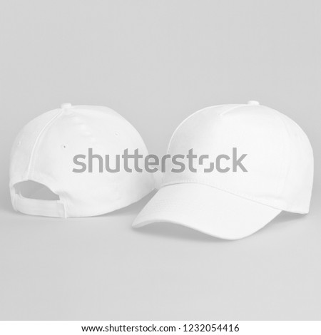 Two white baseball caps isolated on a gray background. Front and back view.   White baseball cap mock up and template Royalty-Free Stock Photo #1232054416