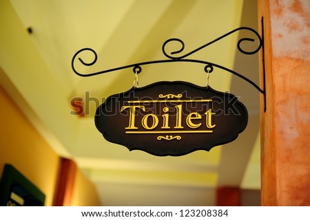 public toilet sign in front of an entrance