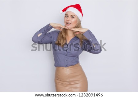 Business woman in Christmas Santa red hat. Smiling blonde girl over white background