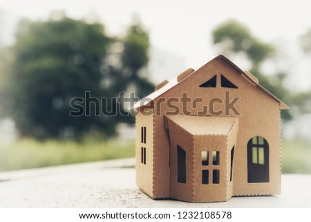 Small model of house with bokeh green background. Copyspace for text or image. 