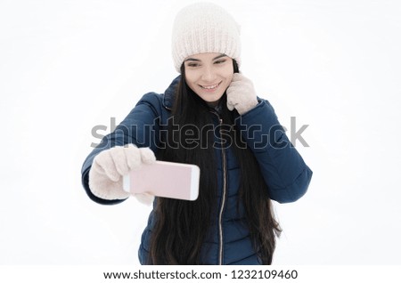 girl with a smartphone calls a friend in the park on a winter day, video call, winter frosty day