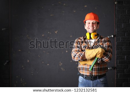 Male architect builder in a protective helmet and with papers in hands
