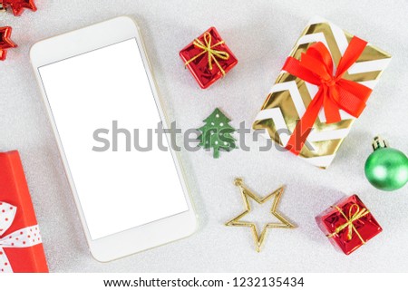 Close up mobile smartphone white screen with copy space for text Christmas New year theme red craft gift box ribbon bow with golden star on glitter background.