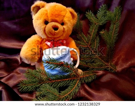 A branch of spruce, cup and toy on the background