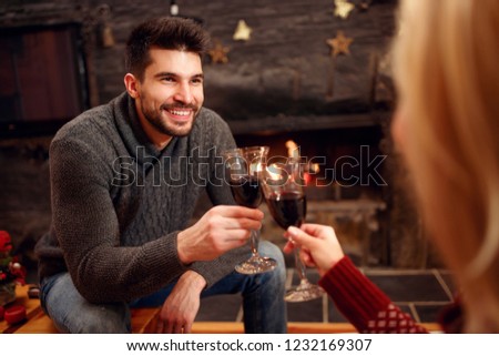 holidays, Christmas, season and people concept - romantic couple toasting delicious red wine
