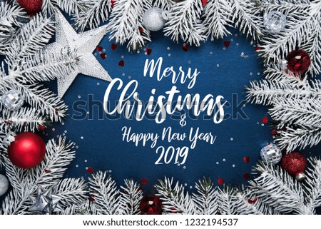 Merry Christmas and Happy Holidays greeting card, frame, banner. New Year. Noel. Christmas ornaments and fir tree on blue background top view. Winter holiday theme. Flat lay.
