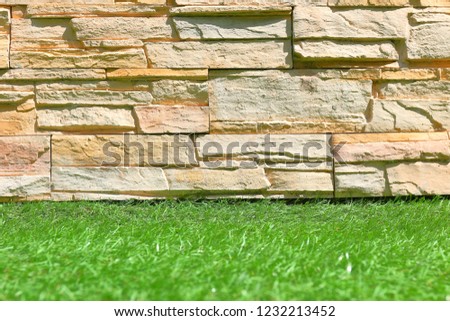 Granite wall on green grass floor.