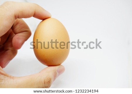 Put eggs into the cup. The left hand is holding the egg.