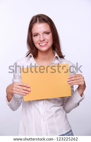 Studio portrait of beautiful young business woman holding paper on Business and Finance theme/Lovely successful business woman holding a banner for your special text