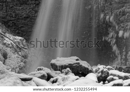 A mountain waterfall in winter, black and white picture