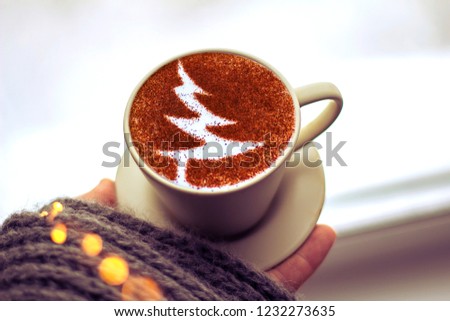 Cappuccino cup with cinnamon Christmas tree symbol on milk froth