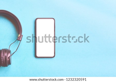 Wireless Headphones and bezelless smartphone on colorful background, top view, copyspace.