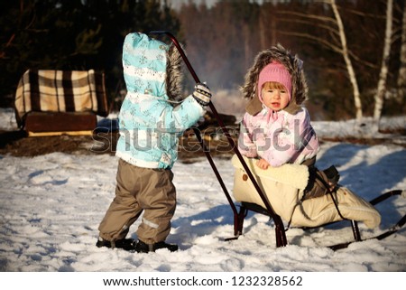 child two outside on the field in winter in warm clothes
