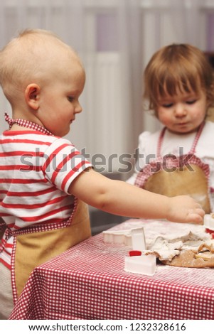 children in an apron are cooking gingerbread cookies in the kitchen