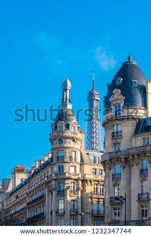 Paris, beautiful buildings, typical facades, with the Eiffel Tower in background 
