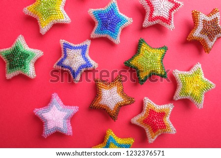 Christmas New Year star stars different colors made from beads handmade on red pink background