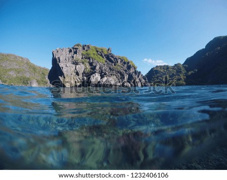 Tropical island landscape with sea and rock formation. Unusual tropical seaside landscape with mountains in sea. Abandoned rocky islands near Palawan, the Philippines. Volcanic island with greenery