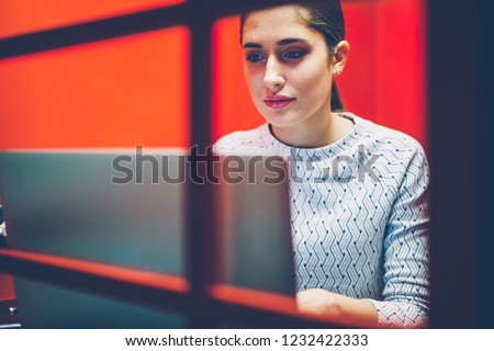 Serious businesswoman making preparation for video conference on laptop computer sitting in noise insulation cabin in office,female manager using application on netbook for making video calls Royalty-Free Stock Photo #1232422333