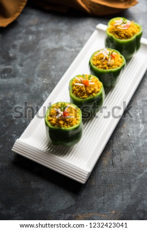 Stuffed  capsicum or bharwa shimla mirchi is a popular Indian main course recipe. Served in a plate over moody background. Selective focus