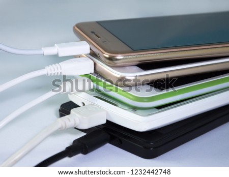 A pile of smartphones, charging through usb cables