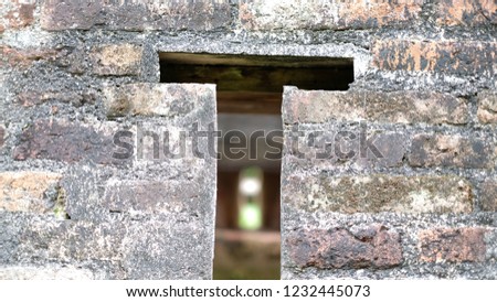 Hole of T sign on a brick wall that we can look through