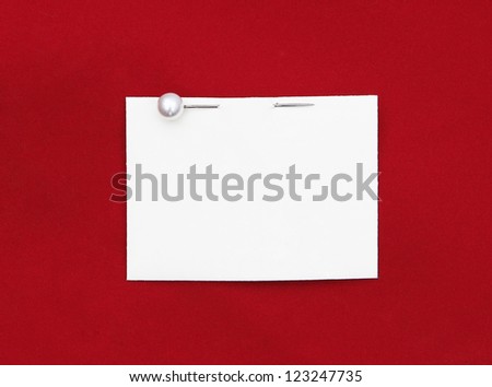 Blank white card with pearl stick pin isolated on red velvet background