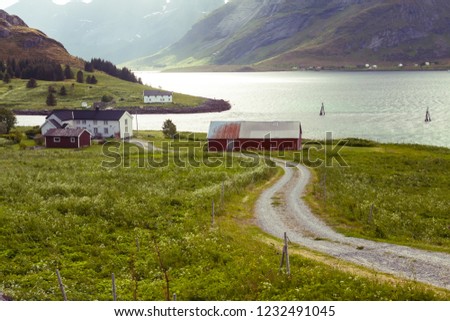 picturesque view of fjord, snow mountains and traditional village, Norway, Lofoten