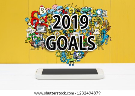 2019 Goals concept with smartphone on yellow wooden background